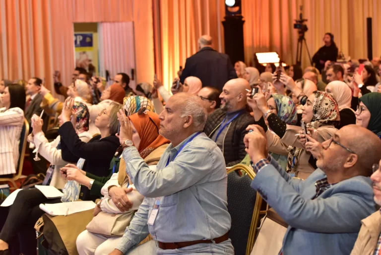 Participants photographiant une présentation, 2ᵉ congrès 2024